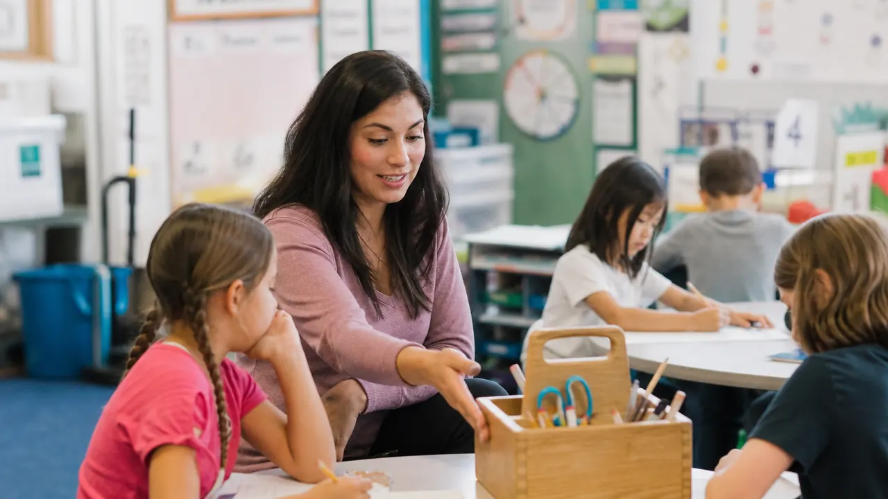 A teacher pointing to a wooden desk organizer on a classroom table group while students work